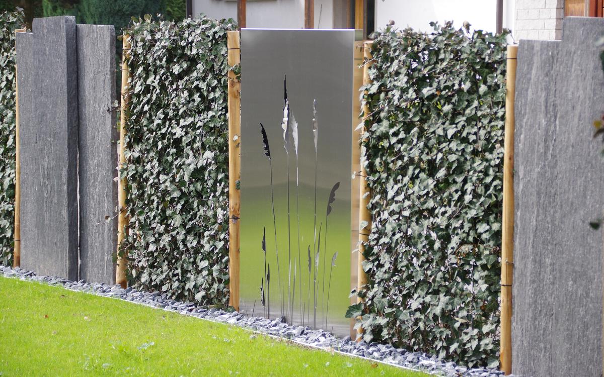 Sichtschutzwände aus Edelstahl mit Gräser-Motiv vor Hecke